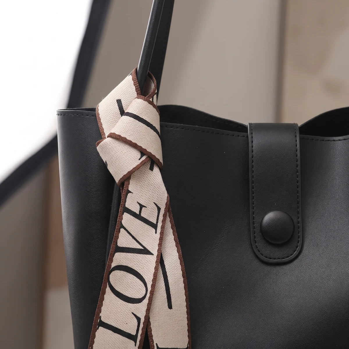 Close detail of the Noir tote centre closure and surface